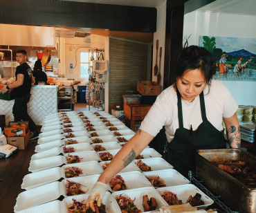 Melissa Miranda fills meal boxes at Musang